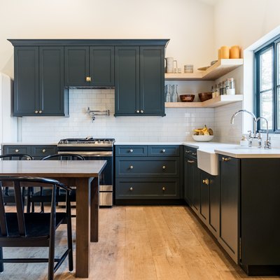 Kitchen with dark gray cabinets, dark dining set, retro-style fridge, white tile backsplash, and wood shelves